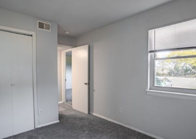 A room featuring a door on one side and a window allowing natural light to enter from the opposite side