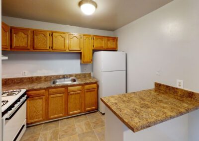 A modern kitchen featuring a refrigerator, stove, and sink, showcasing a functional and organized cooking space