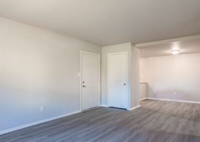 An empty room featuring a single door and a plain white wall, creating a sense of openness and simplicity